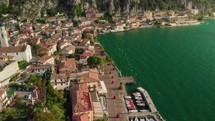 drone flying over old town with church on lake garda
