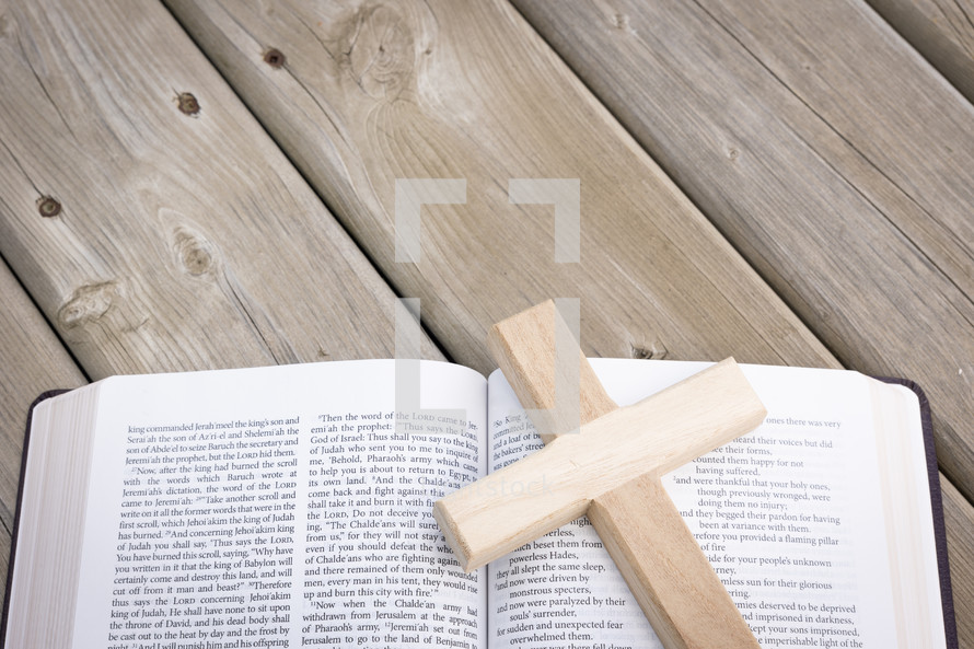 wooden cross on the pages of a Bible 