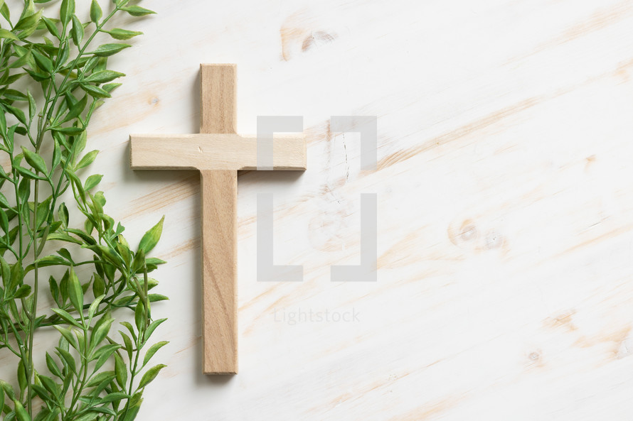 wood cross and green leaves 
