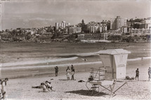 tourists on a beach and lifeguard stand 