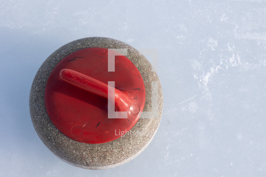 One red curling rock from above on the ice