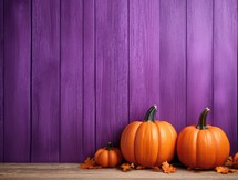 Halloween pumpkins and autumn leaves on wooden background with copy space