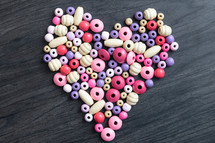 pink and purple beads in the shape of a heart 