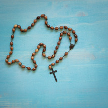 rosary on a blue wood background 