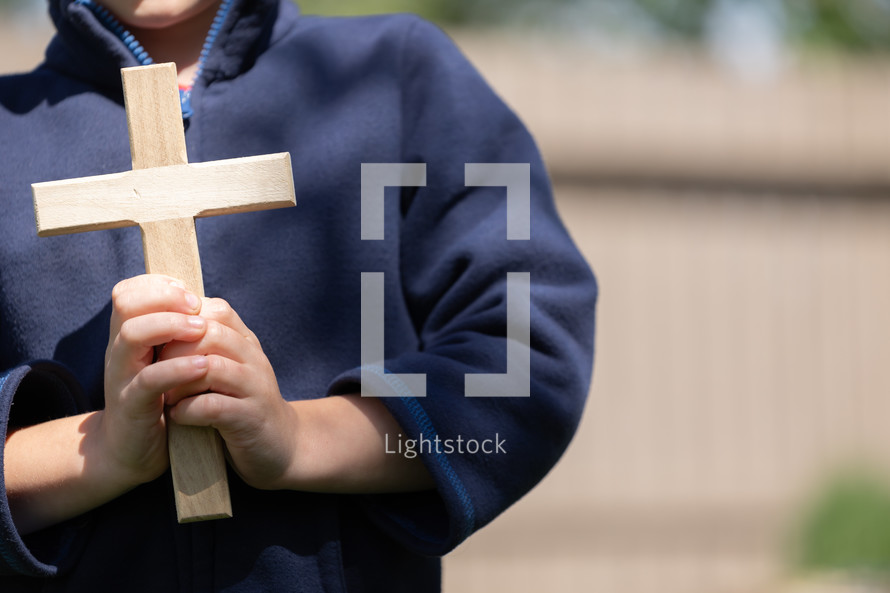 a boy holding a cross 