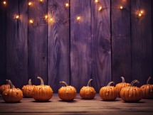 Halloween pumpkins on wooden background with bokeh lights.