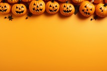 Halloween background with pumpkins on orange background. Copy space.