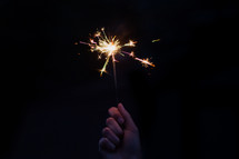 hand holding up a sparkler 