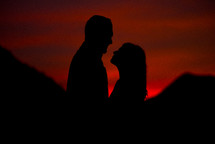 silhouette of a couple at sunset under a red sky