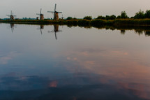 Windmills along a river.