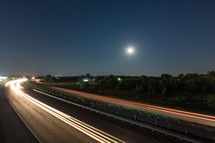 Speeding highway traffic at night.