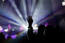 silhouettes of raised hands during a worship service