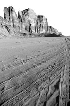 desert mountains and tire tracks in sand 