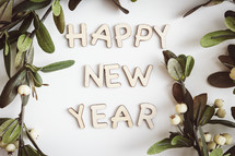 Greenery with white berries and "happy new year" letters