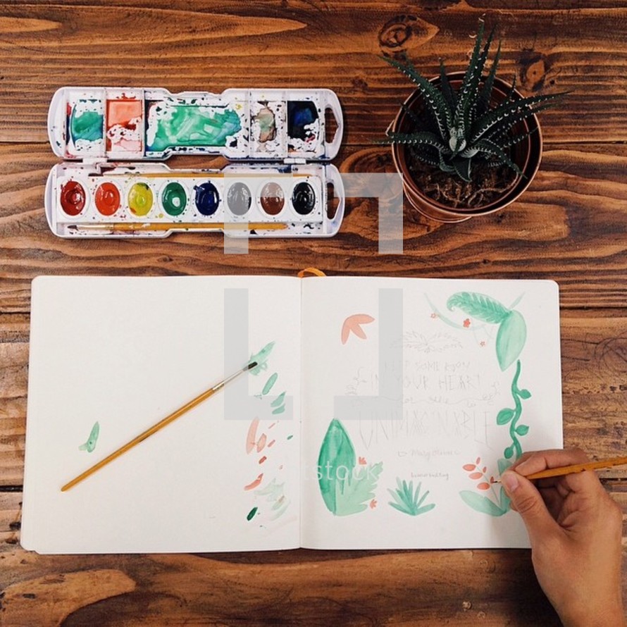 Painting with watercolors at a wooden table.

