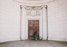 man on a bike in front of wood doors 