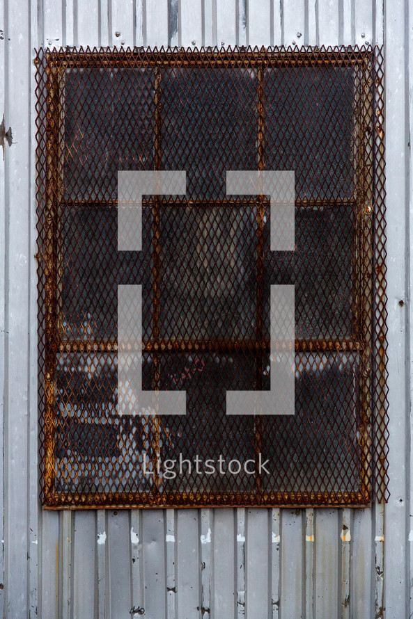 rusted metal cage over a window 