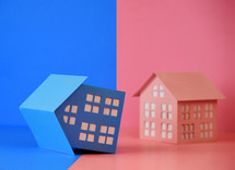 A blue house is tilted over and unbalanced for a boy or girl gender symbolism or gender division.