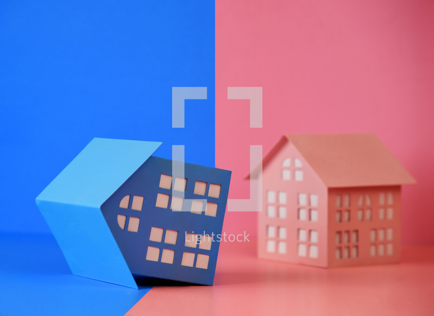 A blue house is tilted over and unbalanced for a boy or girl gender symbolism or gender division.