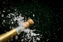 popping the cork of a champagne bottle 