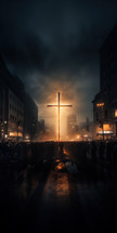 A cross lit up on fire in the middle of the city with large crowds surrounding it. 