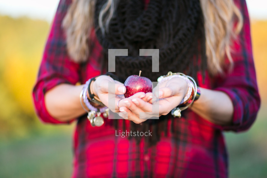 woman holding an apple in cupped hands 
