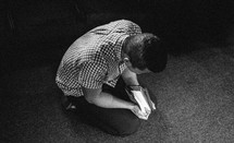 Kneeling with the bible on his hands