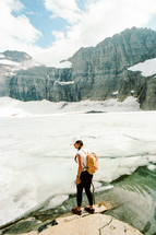 woman standing on a frozen mountain lake shore 