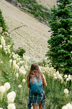 woman hiking through a field of wildflowers 