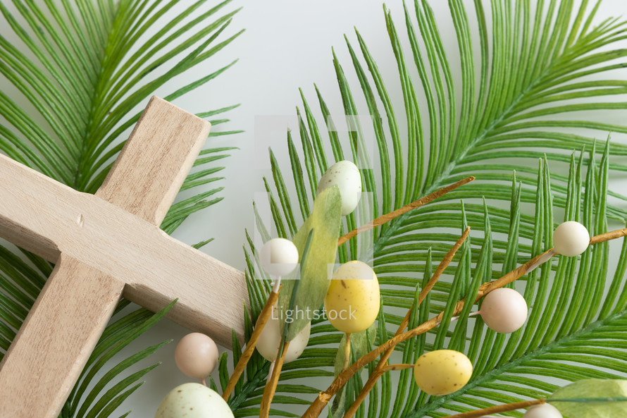 Palm branch with Easter egg decoration and wooden cross