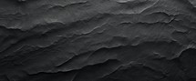 Dark grey black slate background or texture. Close up of black stone.