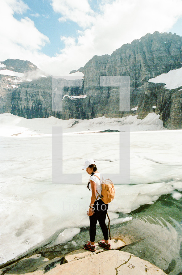 woman standing on a frozen mountain lake shore 