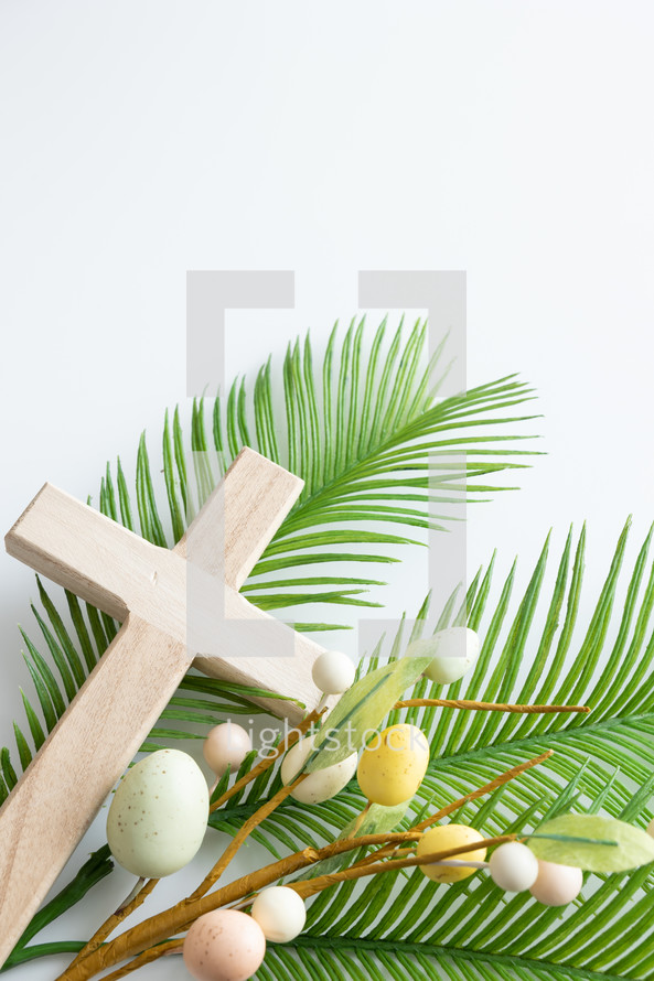 Wooden cross and palm branch with Easter egg decoration