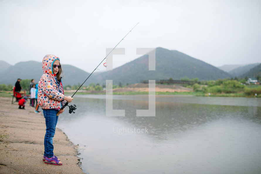 Little girl fishing at the lake 