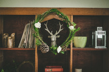 wreath and deer head on a bookshelf 