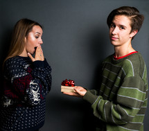 a young couple exchanging Christmas gifts 