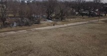 Aerial, drone shot of young man, teenager with backpack and winter coat walking in cinematic slow motion. A young, teen boy walking to high school or young homeless man. 