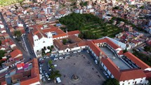 Aerial shot drone circles plaza mirador at top of hill overlooking city