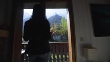Woman at a ski chalet admire mountains window in Chamonix France, slow motion

