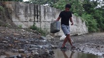 Asian Man Gathers Contaminated Water