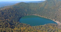Lake Sfanta Ana - Saint Anne Crater Lake With Dense Forest On A Sunny Day In Autumn Season In Romania. - aerial