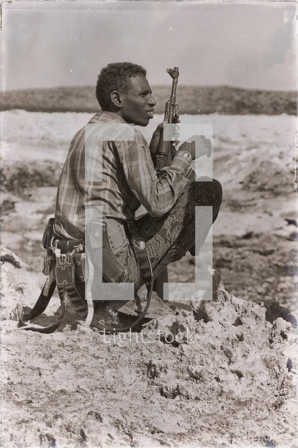 a soldier in Africa holding a gun 