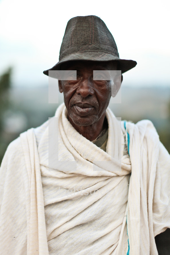 man wearing a hat and a blanket