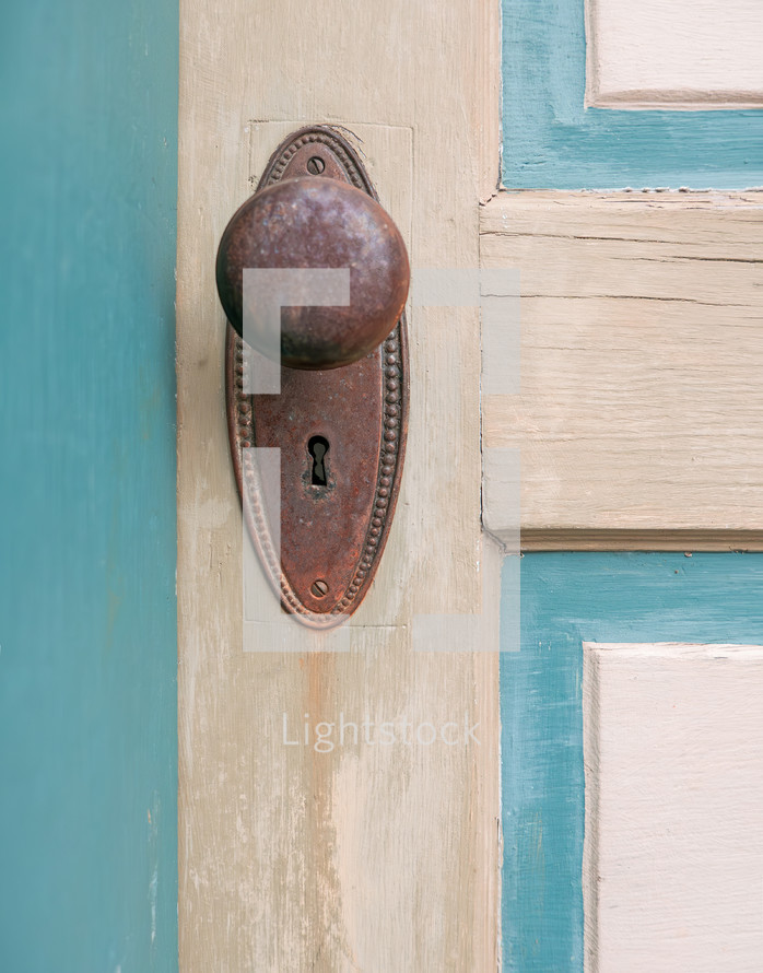 old painted door with rusted vintage knob and keyhole plate