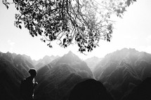 Silhouette of a man hiking through the haze-covered mountains.
