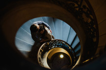 a couple hugging on a spiral staircase 