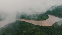 Aerial drone view of Amazonia River in tropical rainforest covered with foggy clouds in Ecuador. 