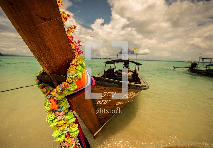 Fishing boat coming ashore in the ocean water in Thailand.