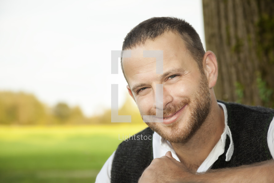 smiling man in a sweater vest 