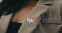 Young woman smiling with an ‘I Voted’ stickers and pin 